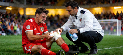 足球运动员受伤接受队医治疗场景